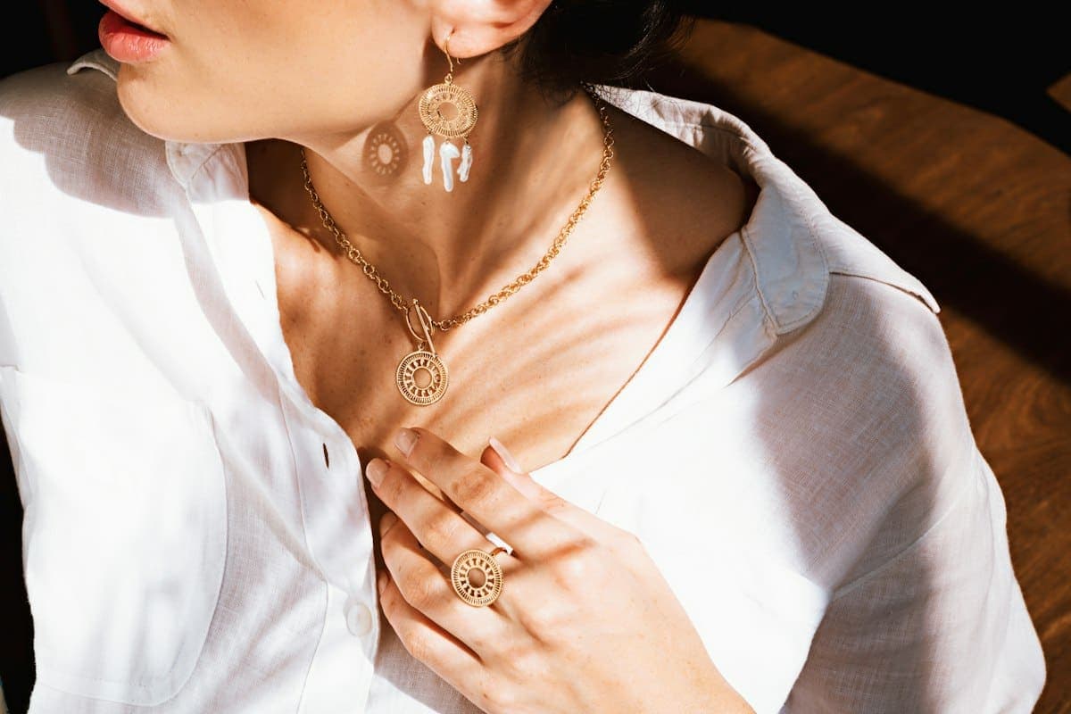 Gold necklaces, earrings and a ring styled together